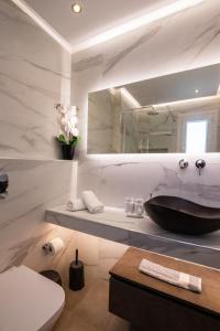 卡尔帕索斯Aronia Luxury Apartments Karpathos的一间带水槽、卫生间和镜子的浴室