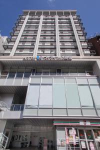 大阪Via Inn Shinsaibashi的一座高大的建筑,有很多窗户