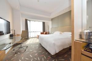 中山永安新城皇冠假日酒店 的配有一张床和一台平面电视的酒店客房