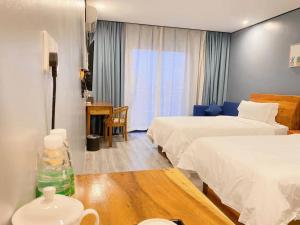 西哈努克Junlan Hotel的酒店客房设有两张床和一张桌子。