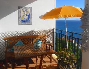 卡尼索Apartment Palma Madeira wandern und tauchen的一个带长凳和遮阳伞的庭院和大海