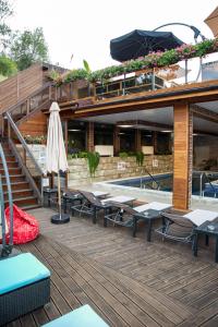 韦林格勒Zarevata Guest House的一个带游泳池、桌子和遮阳伞的度假村