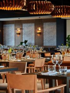 斯克拉斯卡波伦巴Hotel Bergo Resort & SPA的餐厅配有空桌椅和酒杯