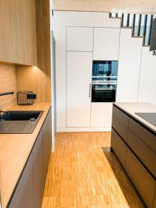 温特贝格Sauerland Lodge - Haus Luise的厨房铺有木地板,配有白色橱柜。