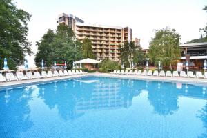 阿尔贝纳Kaliakra Beach Hotel - Ultra All Inclusive的一个带椅子的大型游泳池和一间酒店