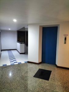 合艾Perfectroom Mansion的建筑物内一个空房间,有蓝色的门