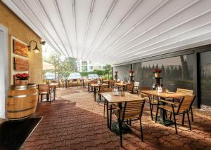 布拉格Prague Hotel Carl Inn restaurant & Free Parking的餐厅设有木桌、椅子和窗户。