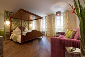 罗滕堡浪漫马库斯图姆酒店的一间卧室配有天蓬床和沙发
