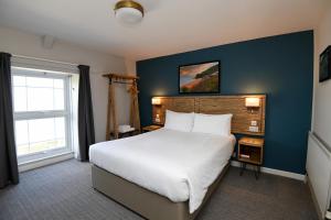 阿博波恩轮船旅馆的卧室配有一张白色大床和蓝色的墙壁