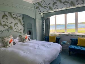班戈北爱尔兰卡恩湾旅舍的一间卧室配有一张床和两张蓝色椅子