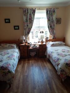 阿伯加文尼The Guest House的一间卧室设有两张单人床和一个窗户。