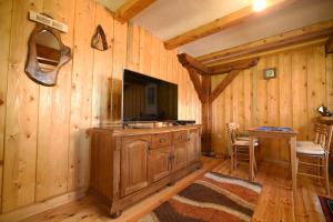 扎布利亚克Cabarkapa Guesthouse的一间带电视和木墙的客厅