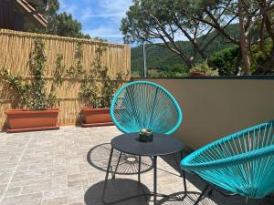 蒙特罗索阿尔马雷Hotel Il colle di Monterosso的庭院里设有两把蓝色的椅子和一张桌子