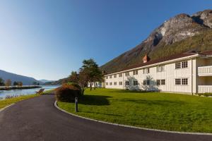 卢恩Hotel Loenfjord Loen的山旁道路边的建筑物