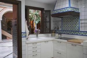 科尔多瓦La casa del Cipres una casa con historia的厨房配有白色橱柜和蓝色及白色瓷砖