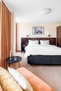 帕兰加Kerpė Hotel & SPA的酒店客房设有一张大床和一张沙发。