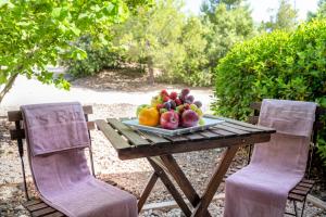 阿尔内斯Hotel Vilar Rural d'Arnes by Serhs Hotels的一张桌子上的一盘水果,两把椅子