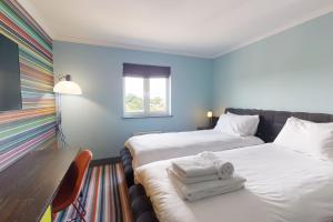伯恩茅斯伯恩茅斯乡村酒店的酒店客房设有两张床、一张桌子和一个窗户。