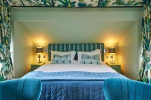 埃克塞特埃克塞特红酒酒店的一间卧室配有一张床和两张蓝色椅子