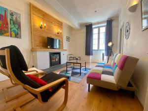 卡尔卡松L'Armagnac的客厅配有沙发、椅子和壁炉