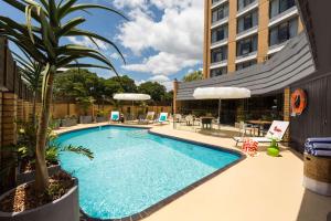 奥尔伯里奥尔伯里阿图拉酒店的一座游泳池,旁边是一座棕榈树