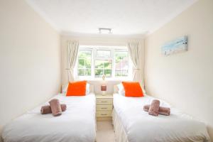 威尔汉姆West Lulworth Apartment的带窗户的客房内设有两张单人床。