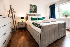 圣奥尔本斯Beech Road Apartment St Albans by PAY AS U STAY的一间卧室配有一张大床和绿色枕头