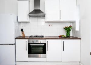 圣奥尔本斯Beech Road Apartment St Albans by PAY AS U STAY的厨房配有白色橱柜和炉灶。