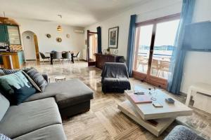 波多河丽Chrysa's Dream - Dreamy Sea View at Spacious 3BR Apt in Porto Cheli的客厅配有沙发和桌子