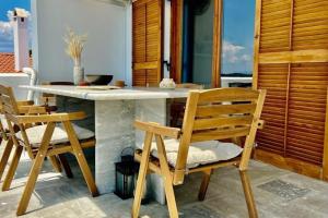 波多河丽Chrysa's Dream - Dreamy Sea View at Spacious 3BR Apt in Porto Cheli的庭院内的厨房配有桌椅