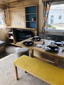 Lytchett MinsterChalet, Balcony, BBQ, sleeps 6, (new 2022)的一间用餐室,配有餐桌和餐具