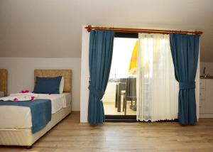 代姆雷Demyra Boutique Hotel的一间卧室配有床和蓝色窗帘的窗户
