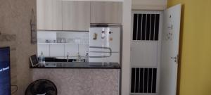 福塔莱萨Cantinho dos Rehm的厨房配有白色橱柜和白色冰箱。