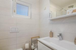 克尔克Apartment Stella di Mare的白色的浴室设有水槽和窗户。