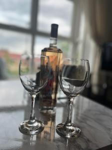 泰恩河畔纽卡斯尔Elite 47 Stays的两杯酒杯坐在柜台上,并配上一瓶葡萄酒