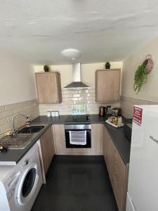泰恩河畔纽卡斯尔Elite 47 Stays的小厨房配有炉灶和洗碗机。