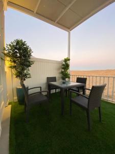 拉斯阿尔卡麦Desert Inn Resort and Camp的海景露台配有桌椅