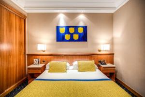 罗马戴克里泽诺酒店的卧室配有一张床,墙上挂有绘画作品