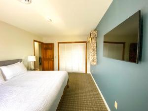 皮茨菲尔德The Central Downtown Inn Suites的一间卧室设有一张床和蓝色的墙壁