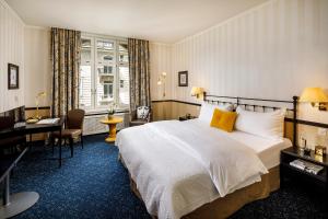 苏黎世Opera Hotel Zürich的配有一张床和一张书桌的酒店客房