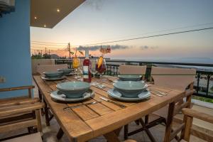 库基尼坎尼奥Villa "A casa d' Irene"- Seaview Villa with private pool的阳台顶部的木桌,配有碗和盘子
