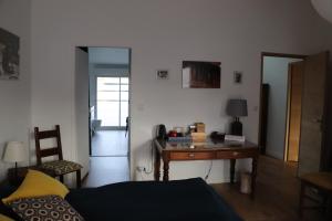 波尔多CHAMBRES chez l'habitant Córdoba et Lhassa的客厅配有书桌和床。