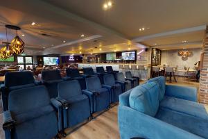 伯恩茅斯伯恩茅斯乡村酒店的一间设有蓝色椅子的等候室和一间酒吧