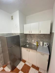 比哈奇Apartman Citylux的厨房配有不锈钢冰箱和白色橱柜