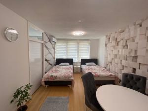 比哈奇Apartman Citylux的一间设有两张床和一张桌子及椅子的房间