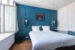 布鲁日Zakske13 - Design Boutique B&B in Bruges city centre的蓝色的卧室设有白色的床和蓝色的墙壁