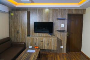 加德满都Hotel Airport Deepshree的客厅配有沙发和墙上的电视