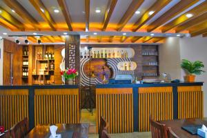 加德满都Hotel Airport Deepshree的餐厅内的酒吧配有桌椅