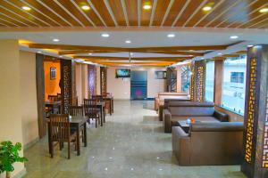 加德满都Hotel Airport Deepshree的一间带沙发和桌椅的餐厅