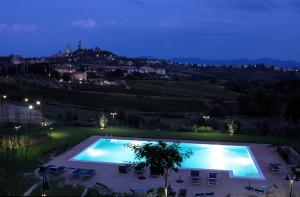 圣吉米纳诺杜慈别墅酒店的享有城市美景的夜间游泳池
